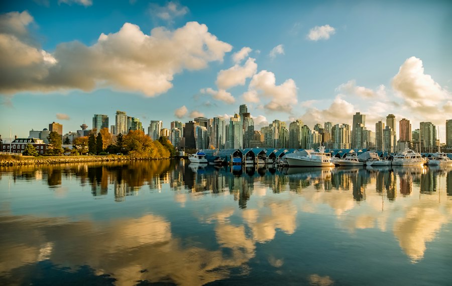 Boats and towers reflected in still water at Coal Harbour